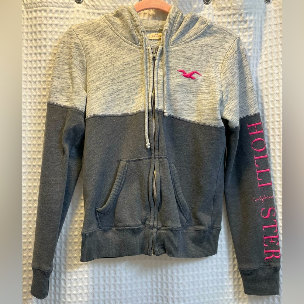 Gray Hollister zip up hoodie with pink lettering.
